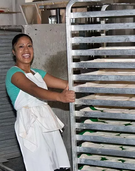 Maria Tores wheels dough to the oven for baking at Sweis's Pita Bakery. (Mark Hancock)