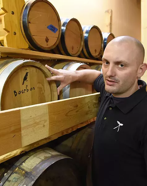 Jarrett Janko with kegs of Bourbon at Scissortail Distillery. (Mark Hancock)