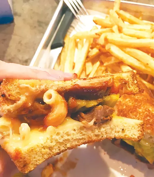 The Mac Street Boys is pulled pork and jalapeño macaroni and cheese topped with Muenster cheese, spicy barbecue sauce and sweet pickle on jalapeño bread. - JACOB THREADGILL