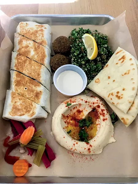 A shawarma wrap with falafel, tabbouleh, hummus, garlic sauce, pita bread and pickled vegetables - JACOB THREADGILL
