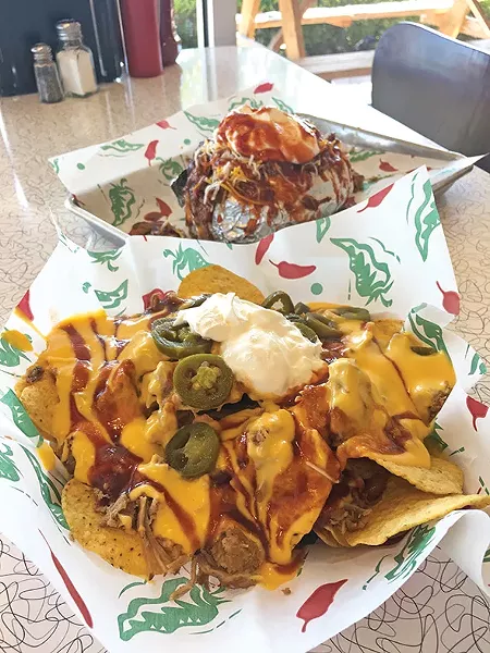 Big O baked potato with pulled pork, baked beans, cheese and sour cream and a half order of barbecue nachos - JACOB THREADGILL