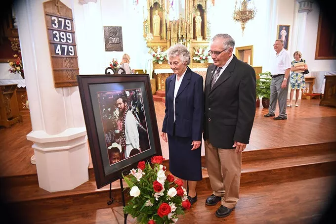 Sister Marita Rother and Tom Rother, siblings of Father Staley Rother with their deceased brothers portrait, after the Anniversary Mass for Father Stanley Rother at the Holy Trinity Catholic Churche in Okarche Oklahoma on Aug. 1. mh