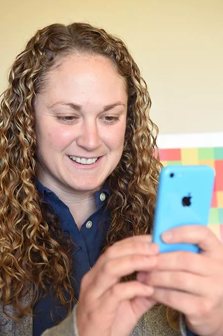 Allison Cofer, the new president of Woven, looks at the new Kickstarter app on a cell phone. mh