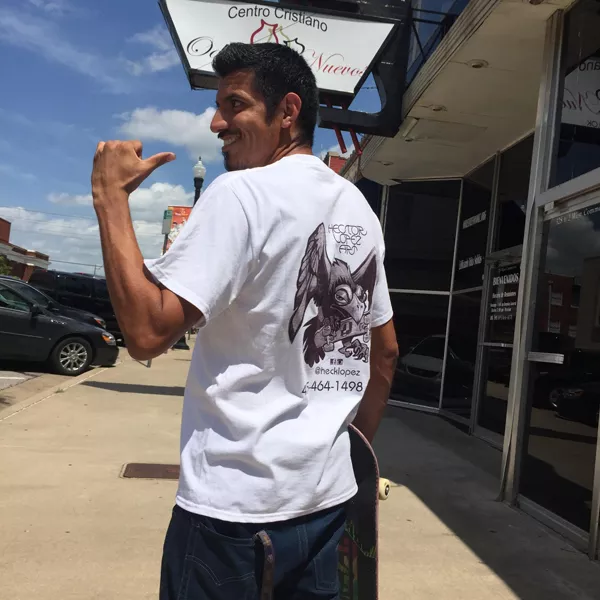 Hector Lopez points to the back of his T-shirt, which features one of his illustrations and his logo.