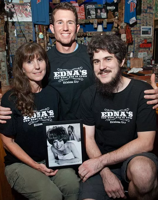 Edna's daughter, Tammy Lucas with sons, from left, Nathan Lucas and Michael Whitley, pose with a well known portrait of Edna, at the bar inside Edna's. mh