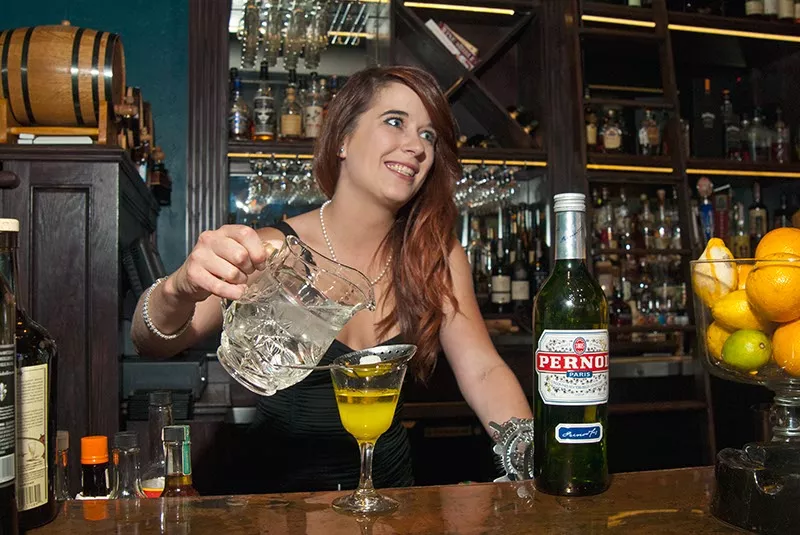 Sierra Brown prepares to poor chilled water over the suger cube while concocting Absinthe made with Pernod of Paris, at WSKY Lounge. mh