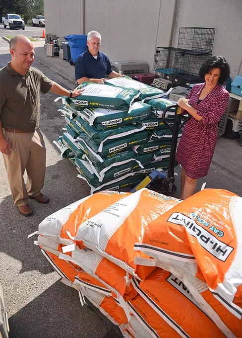 Julie Bank, animal welfare superintendent with the Oklahoma City Animal Shelter, receives donation of dog and cat food from Shawnee Milling Company's, left to right, Joe Ford, vice president of operations, and Brent Thompson, feed sales director 9-24-15. (Mark Hancock