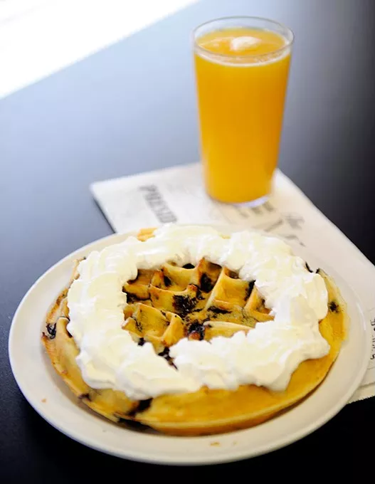 Blueberry waffle with whipped cream and orange juice at Around the Corner in Edmond, Wednesday, Feb. 11, 2015. - GARETT FISBECK
