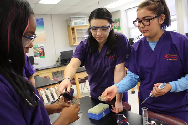 from left Marilu Cardenas and Cassidy Lopez perform a bio lab at Northwest Classen High School. They are part of the first graduating class of the school’s Academy of Health Sciences. | Photo Laura Eastes