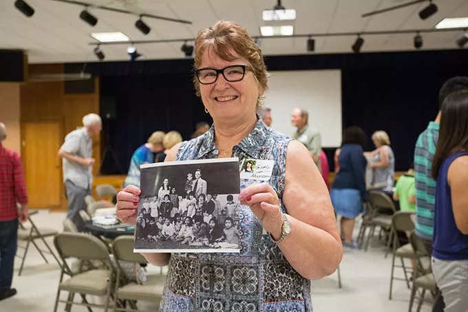 Gisela Huyssen holds a photo of the 23 children with her and her husband. Gisela Huyssen and her husband Ulrich Huyssen adopted 23 Vietnamese children to American families at the end of the Vietnam war on Saturday, July 2, 2016 in Oklahoma City. - EMMY VERDIN