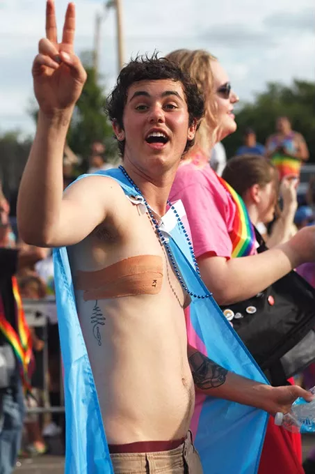 Alex Cargo holds up a peace sign while walking down 39th St. during the Pride Parade on Sunday, June 25, 2017. (Cara Johnson).
