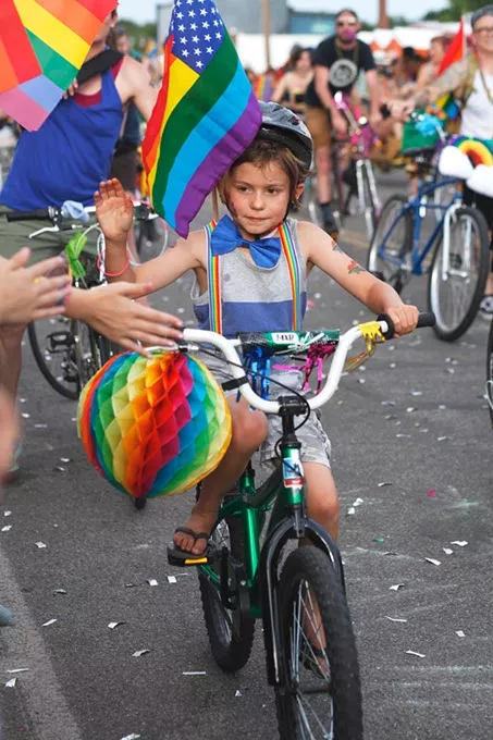 A young child rides their bike with the Bike Brigade during the Pride Parade on Sunday, June 25, 2017. (Cara Johnson).