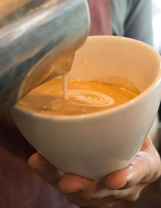 A barista creates latte art at Elemental Coffee, Monday, May 15, 2017. - CARA JOHNSON