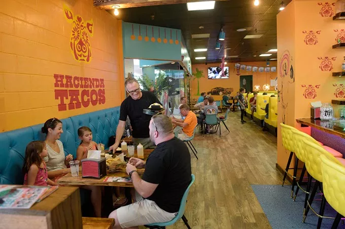 Manager Ron Sterling takes orders to a table at Hacienda Tacos