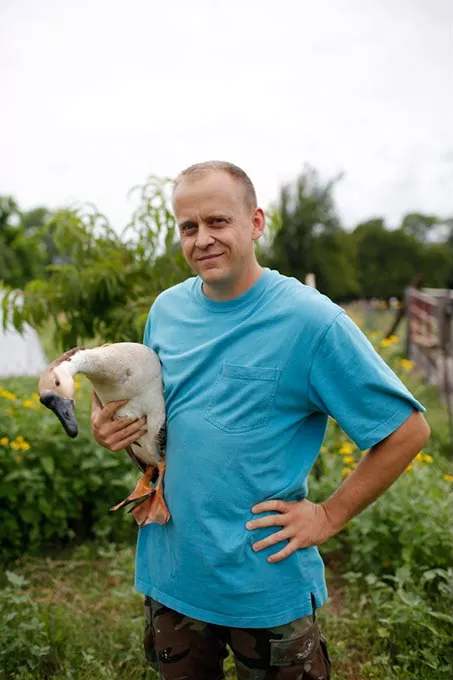 Wes Tibbs holds a goose at his farm in Oklahoma City, Friday, June 24, 2016. "We got into it because it's a marketing angle for when we move beyond the hobby farm level. I think they're a really good organization, in that, they provide people who are doing far bigger things than I am doing an opportunity to get their name out there and get a different angle on marketing that a lot of people don't have.... As consumers are moving toward the locally grown movement, it really gives them a leg up to join the locally grown movement." - GARETT FISBECK