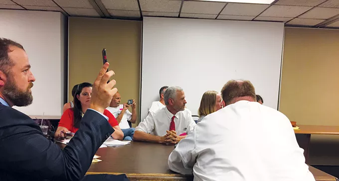 Attorney Ron Durbin left and Oklahomans for Health founder Chip Paul center watch - a live broadcast of the Aug. 1 special State Board of Health meeting from an overflow room inside the health department offices. - BEN LUSCHEN