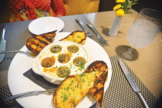 Escargot is served in garlic and parsley butter with grilled bread. - JACOB THREADGILL