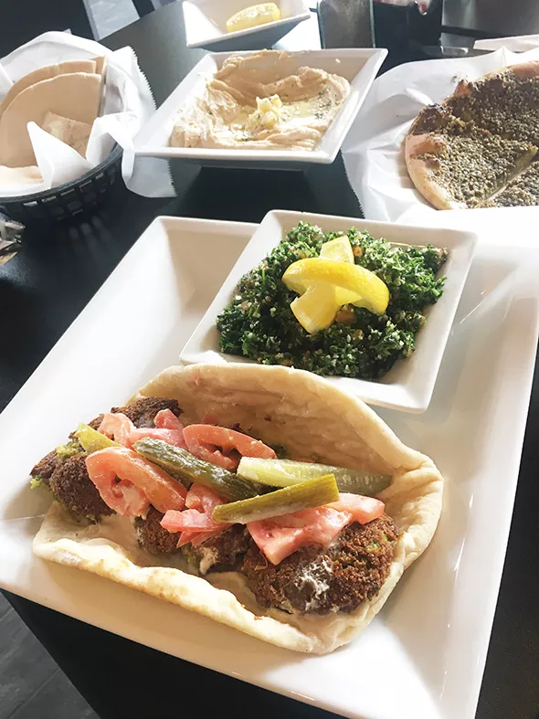 A falafel sandwich with a side of tabbouleh - JACOB THREADGILL