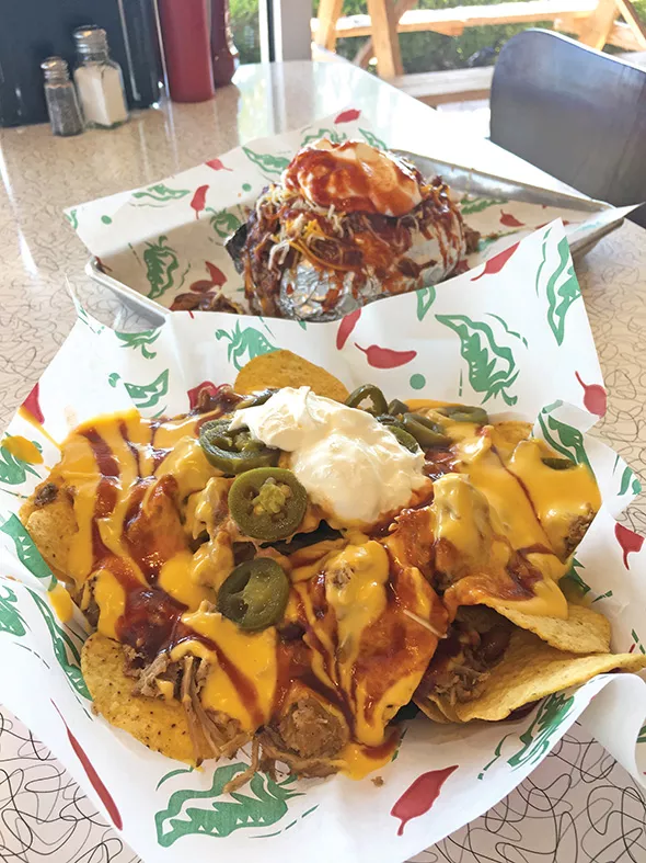 Big O baked potato with pulled pork, baked beans, cheese and sour cream and a half order of barbecue nachos - JACOB THREADGILL