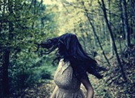 Scared young woman running through a forest at night looking back - BIGSTOCK