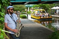 Out of the Box performer, David Bruster, plays along the Bricktown Canal as a Water Taxi, "captive audience" cruises his way, 7-19-14.  mh  mh