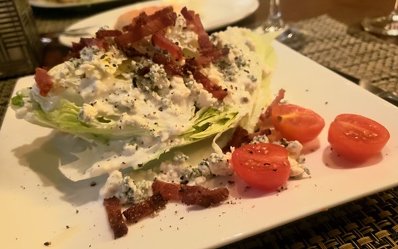 Classic wedge salad topped with bacon lardons and Danish blue cheese. - HOLLY V. KAPHERR
