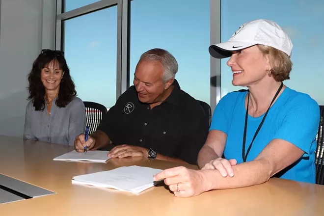 Monica Rivers, John Rivers and Lesa France Kennedy signing the contract to bring the newest 4 Rivers Smokehouse to One Daytona - COURTESY 4R RESTAURANT GROUP
