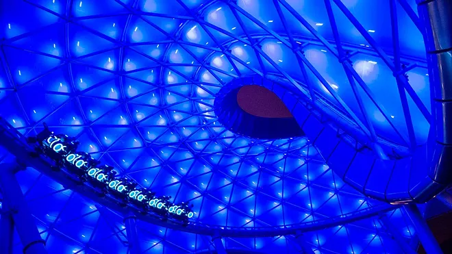 A Tron coaster car in the outside portion of the ride under the roof structure at Shanghai Disneyland - IMAGE VIA DISNEY