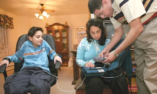 Enas (center) and Magdy Habib administer the nightly infusion of a medical solution that provides nutrients their son, Pierre. - PHOTO: HEATHER MULL