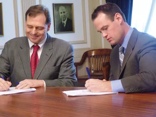 Mark Flaherty, left, signing a service consolidation agreement with Mayor Luke Ravenstahl in April, says the county should "get in business" with Marcellus Shale drillers to see the greatest economic return. - LAUREN DALEY