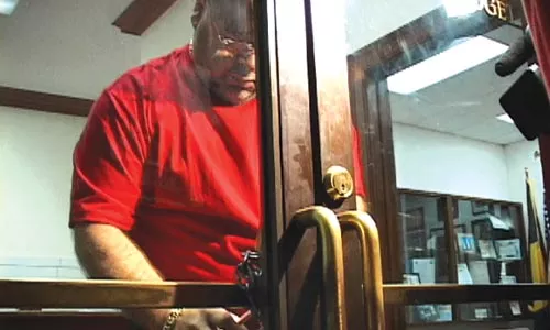 Putting out the welcome mat, Pittsburgh style: With protesters crowded in the hallway outside, a city employee locks the front door to the mayor's office with a chain and padlock. - CHRIS POTTER