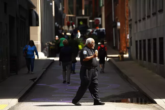A security guard crosses Strawberry Way in Downtown Pittsburgh - CP PHOTO: JARED WICKERHAM