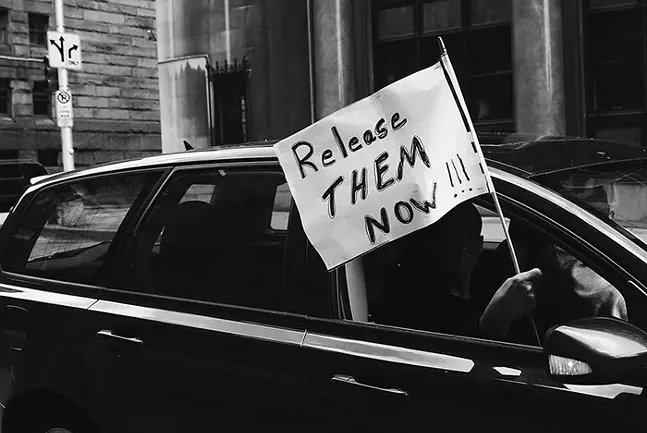 A car-only rally drives past the Allegheny County Jail in Downtown Pittsburgh. - CP PHOTO: JARED WICKERHAM