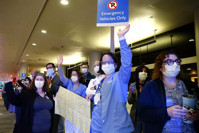 Pittsburgh healthcare workers wave thanks to a first responders procession on Wed., May 6, 2020. - CP PHOTO: JARED WICKERHAM