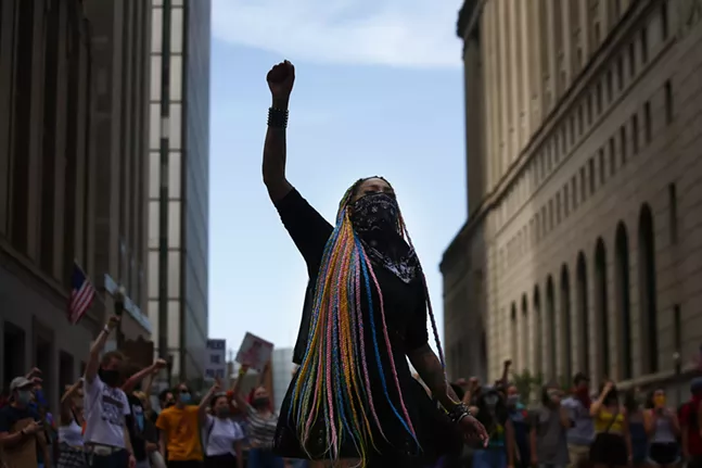 Toy Slaughter raises a fist during a youth-led march against police brutality and environmental racism in Downtown. - CP PHOTO: JARED WICKERHAM
