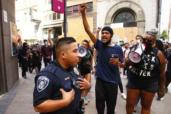 Protesters shout at Port Authority Police officers as they pass by Wood Street T station in Downtown. - CP PHOTO: JARED WICKERHAM