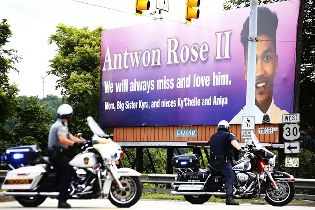 Pennsylvania State Police and North Versailles Police sit in front of the Antwon Rose II billboard. - CP PHOTO: JARED WICKERHAM