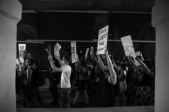 Demonstrators march underneath the East Busway through Wilkinsburg during a march for Juneteenth. - CP PHOTO: JARED WICKERHAM