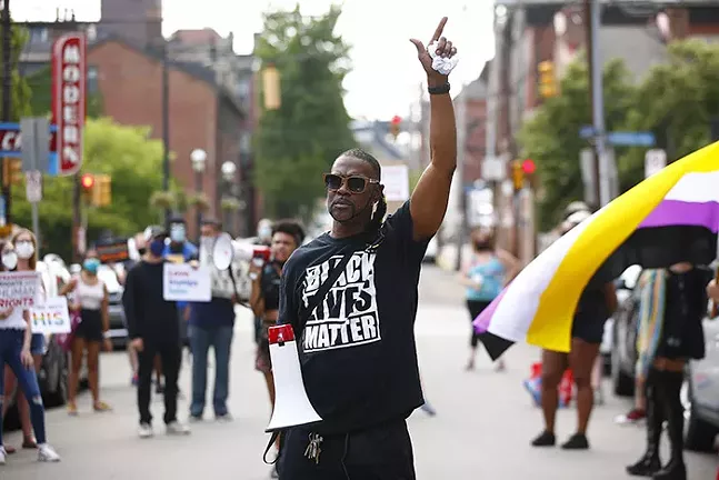 Protesters stand outside of the Delta Foundation offices on the North Side. - CP PHOTO: JARED WICKERHAM