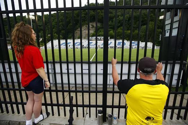 Fans at midfield watch the game through the fence along the Three Rivers Heritage Trail. - CP PHOTO: JARED WICKERHAM