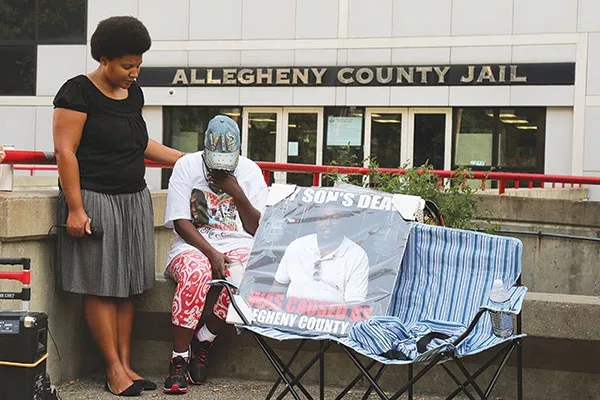 At a recent vigil, Julia Johnson consoles Tomi Lynn Harris, whose son died at the Allegheny County Jail in January. - PHOTO BY THEO SCHWARZ