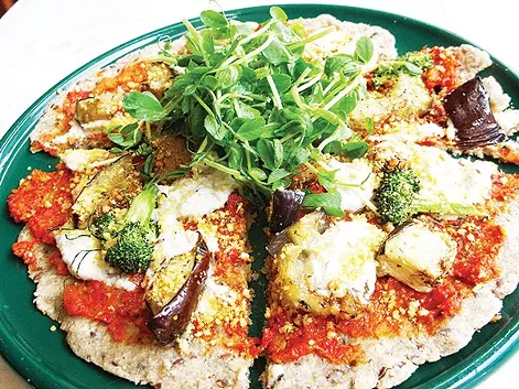 Raw vegan pizza with sundried-tomato basil sauce, cashew ricotta, dehydrated seasonal vegetables, pine-nut parmesan and pea shoots - PHOTO COURTESY OF MYA ZERONIS