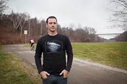 Four Mile Run resident Tom D’Andrea stands near the southern entrance of the Junction Hollow Trail, where the proposed shuttles will run through. - PHOTO BY HEATHER MULL