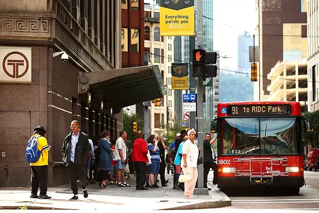 People wait for a Port Authority of Allegheny County bus in Downtown Pittsburgh - CP PHOTO: JARED WICKERHAM