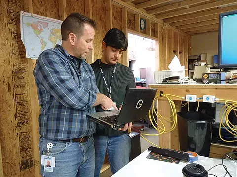 Kevin Driscoll, of Computer Reach, and volunteer Pietro Curigliano work on refurbishing computers. - PHOTO BY ASHLEY MURRAY