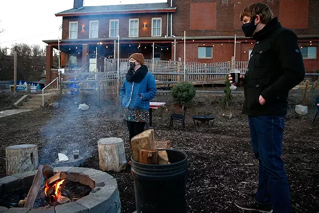 Carrie Wittig and Michael Cunningham enjoy beers in front of a fire pit at Spring Hill Brewing. - CP PHOTO: JARED WICKERHAM