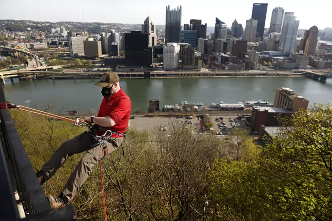 Matt Tolbert of the Explorers Club of Pittsburgh rappels down from the overlook as part of the Pittsburgh Parks Conservancy’s 28th annual Emerald View Park cleanup event in Mount Washington on Sat., April 10. - CP PHOTO: JARED WICKERHAM