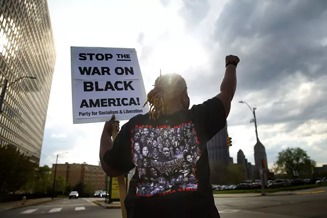 Dajsua Streater raises a fist and holds up a sign before protesters march from Freedom Corner in the Hill District to Flagstaff Hill in Oakland after a guilty verdict on all charges was announced against Derek Chauvin in the murder of George Floyd on Tue., April 20. - CP PHOTO: JARED WICKERHAM