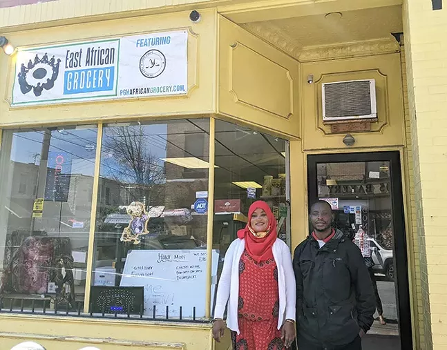 Abdulkadir Chirambo, right, and his wife pose in front of their East African Grocery store in McKees Rocks. - PHOTO: COURTESY OF JUST HARVEST