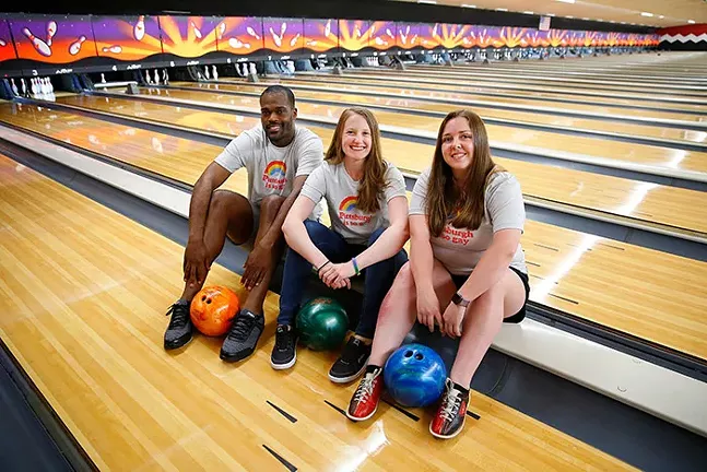 Michael Gosha (captain of Balls Of Steel), Megan Entwistle (captain of Lickity Splits), and Lindsey Williams (captain of The Karen’s) wearing Steel City Clothing's "Pittsburgh is So Gay" Pride T-shirts. - CP PHOTO: JARED WICKERHAM